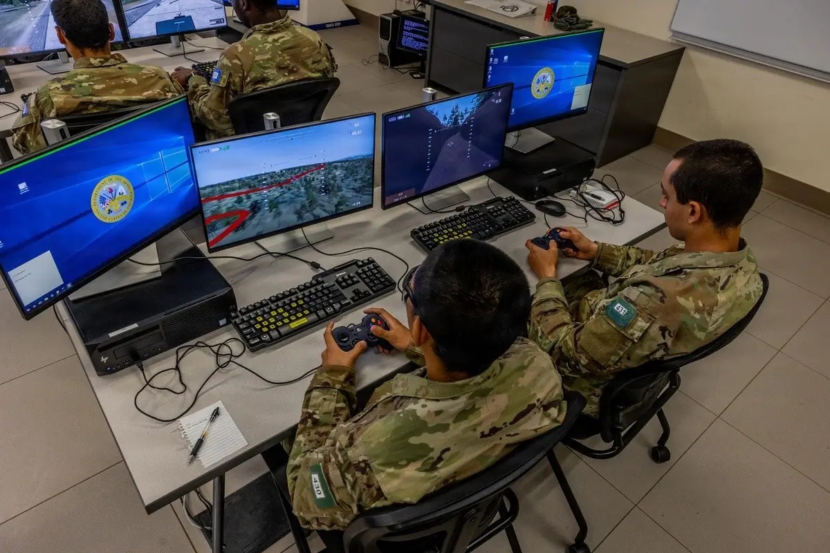 Soldiers training at simulation workstations showing flight and terrain displays