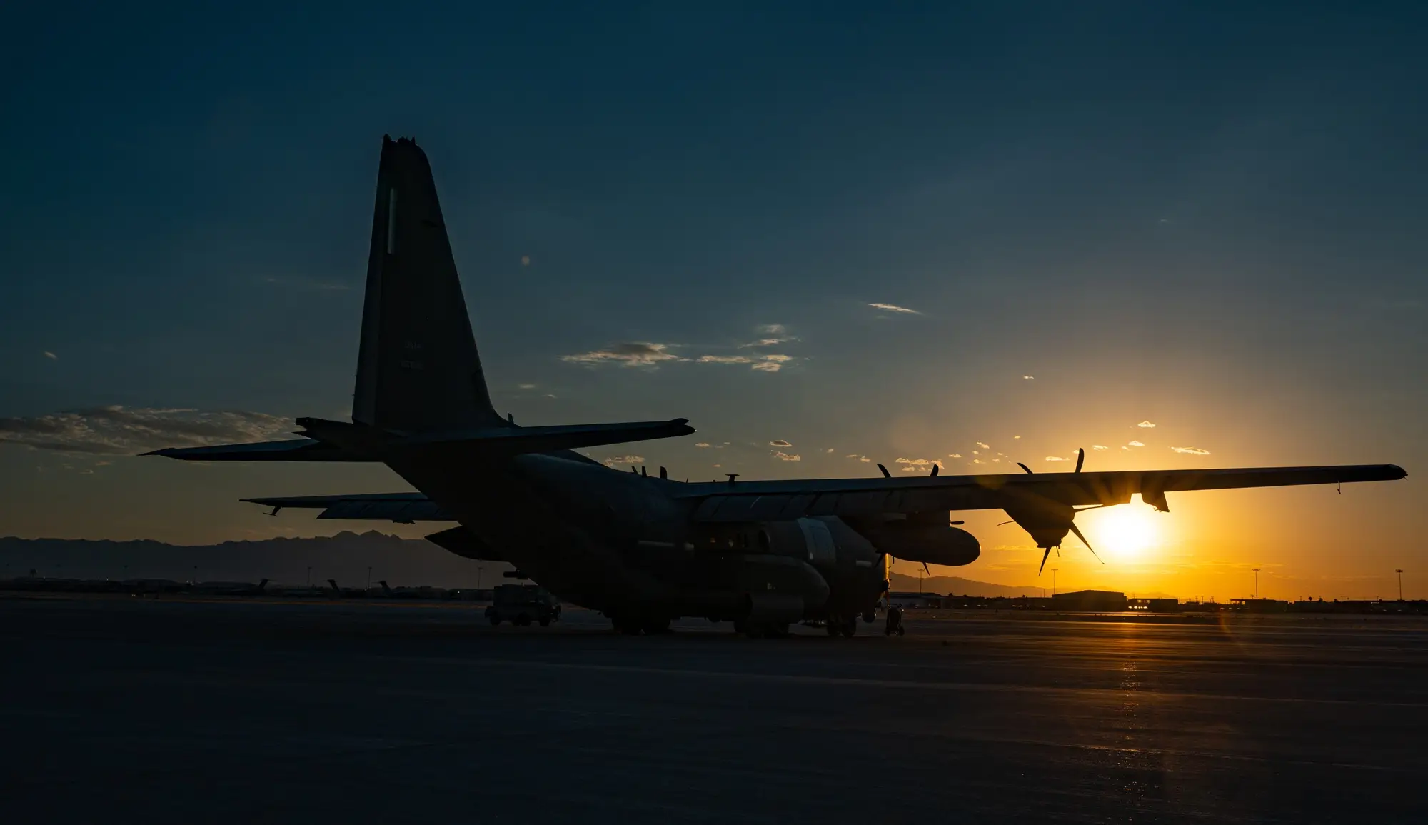 AC-130J Ghostrider gunship silhouetted on the flightline at sunset