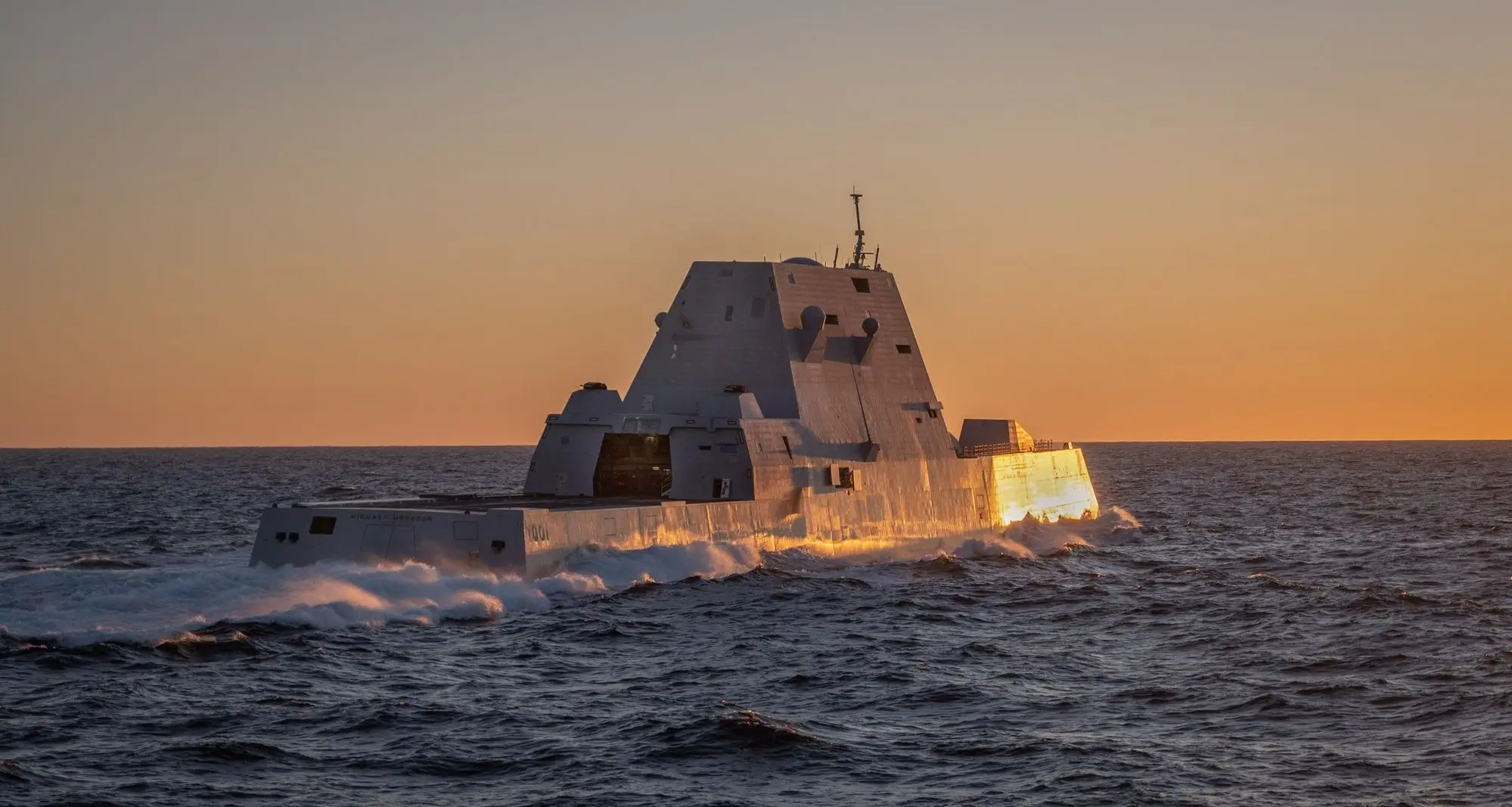 Stealth destroyer underway at sunset