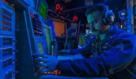 Sailor at a console during a combat systems training drill at sea